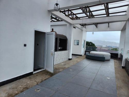 a large living room with a couch and a tv at Rooftop Villa in Freetown