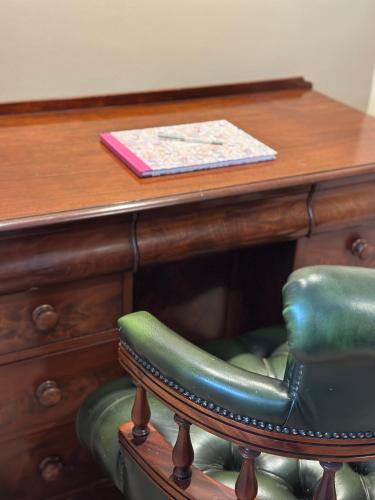 a desk with a green chair and a wooden table at Perfectly Positioned Hambleden House in Henley on Thames