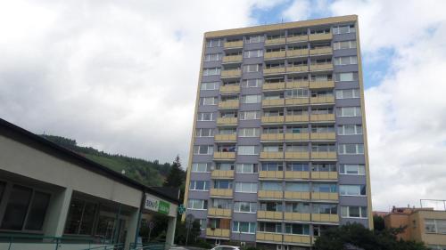 a tall apartment building in front of a building at Byt s jedinečným výhledem in Děčín