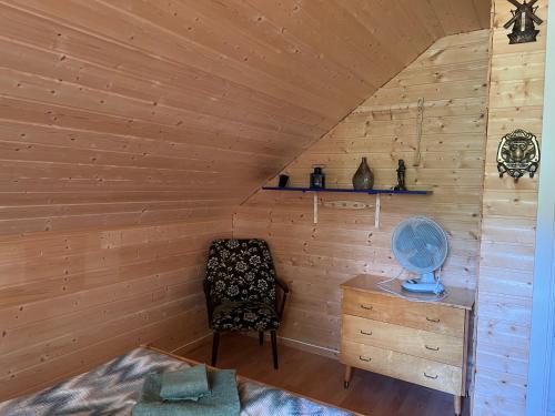 a room with a chair and a table in a cabin at Bestefarhuset in Hakkstabben