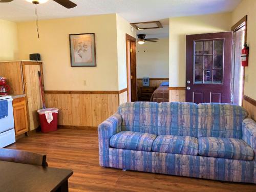 a living room with a blue couch and a kitchen at Outback Campground and Marina in Trinity