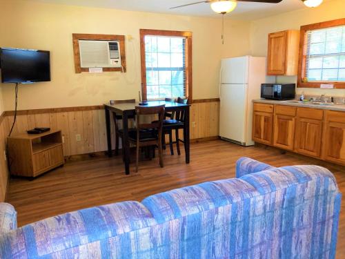 a living room with a couch and a table and a kitchen at Outback Campground and Marina in Trinity