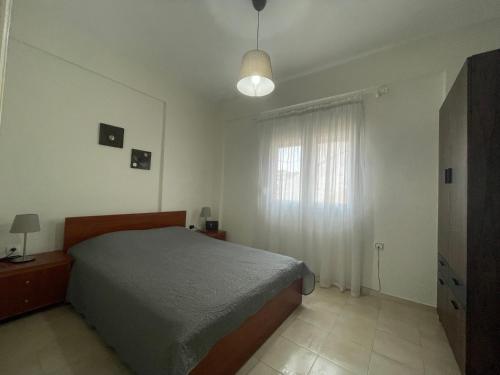 a bedroom with a bed and a window at Evi's apartment Pefkochori in Pefkochori