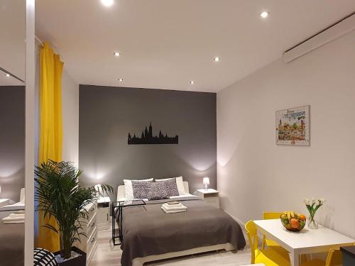a bedroom with a bed and a desk and a table at L-2 Kraków Center Studio O&P ApartFamily in Kraków
