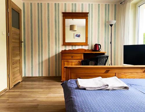 a bedroom with a bed and a desk and a mirror at Willa Karolinka in Łeba