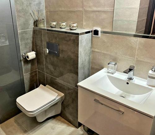 a bathroom with a toilet and a sink at SOSNOWA Apartament in Ełk