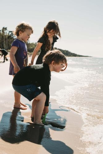 a group of children playing on the beach at Domki U Edzia in Kopalino