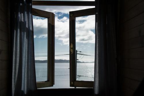 an open window with a view of the water at Hostal Mundo Nuevo in Ancud