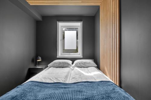 1 dormitorio con 1 cama grande y ventana en Arctic Homes - Premium Plaza en Tromsø