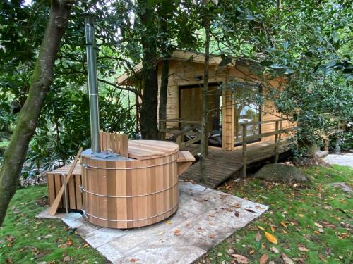 a tree house with a hot tub in front of it at Entre Os Ríos - Casa Rural y Enoturismo in A Pobra do Caramiñal