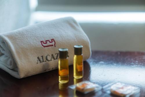 two bottles of oil on a table next to a towel at Hotel Alcazar - Guadalajara Centro Historico in Guadalajara