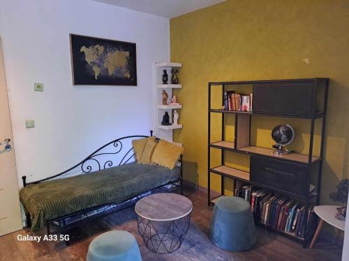 uma sala de estar com um banco e uma estante de livros em chambre appartement terrasse em Fréjus