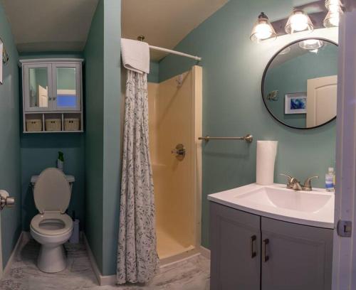 a bathroom with a toilet and a sink and a mirror at 3 Bedroom Pool PlayArea CampFire Cozy Apt in Bar Harbor
