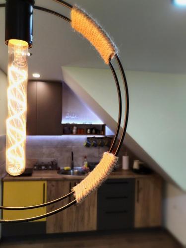 a lamp with a feather hanging from a staircase at NIKAS Apartman in Donji Milanovac