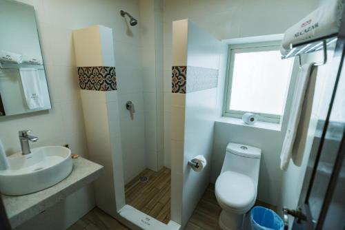 a bathroom with a sink and a toilet and a window at Hotel Alcazar - Guadalajara Centro Historico in Guadalajara