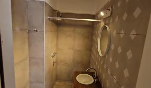 ein Bad mit einer Dusche, einem Waschbecken und einem Spiegel in der Unterkunft Nueva Buena in Guaymallen