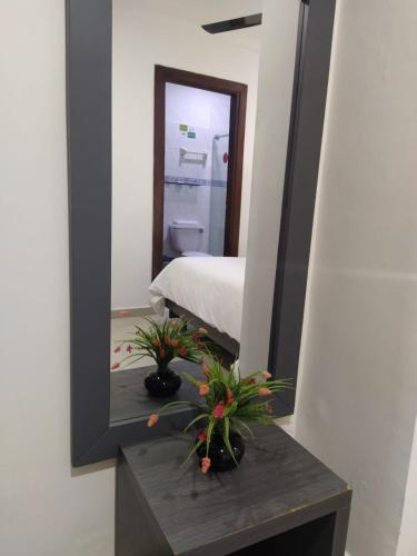 a mirror on a table in a room with a bed at Hotel La Casa 1 in Montería