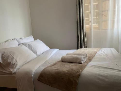 - un lit blanc avec une serviette dans l'établissement Private,secure 1bedroom in Nairobi west, à Nairobi