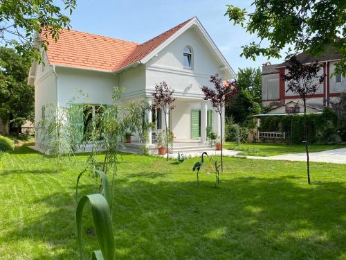 a house with two birds in the yard at Villa Rosa Centre in Balatonfüred