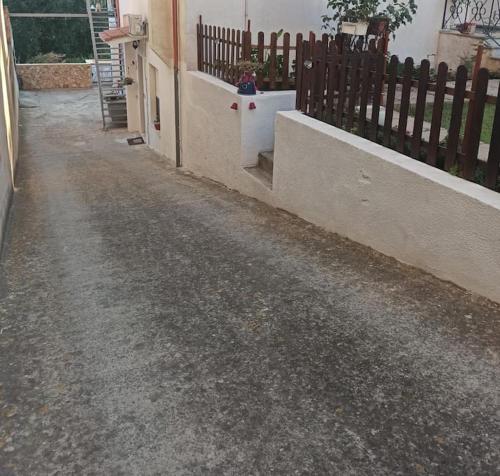 an empty street with a fence and a building at Casa Vacanze Gio&le in Domusnovas