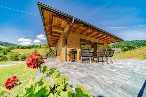 a wooden cabin with a table and chairs on a patio at Domek w Górach in Wierchomla Wielka