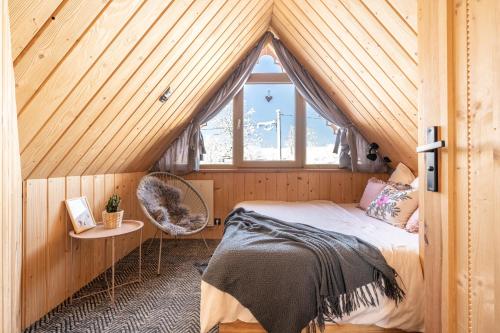a bedroom with a bed and a window in a attic at Stylowa Chata in Zakopane