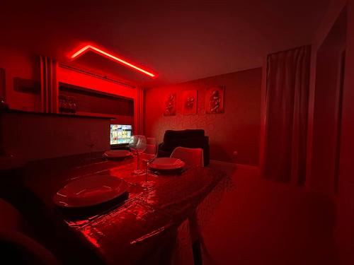 a red room with a table with plates and wine glasses at l'Aphrodite in Huttenheim