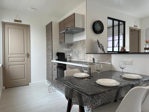 a kitchen with a table with two wine glasses on it at l'Aphrodite in Huttenheim