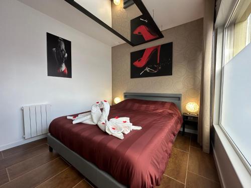 two stuffed animals sitting on a bed in a bedroom at l'Aphrodite in Huttenheim
