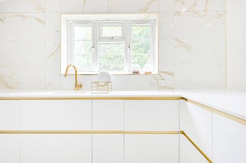 a white kitchen with a sink and a window at PREMIUM Private Apartment minutes to Central London in London