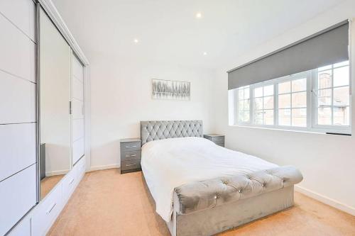 a bedroom with a bed and a large window at PREMIUM Private Apartment minutes to Central London in London