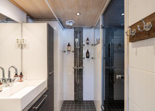 a bathroom with a shower and a sink at Villa Einola- modern rivercottage with jacuzzi in Pori