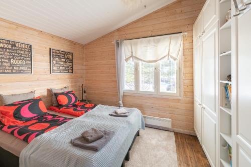 a bedroom with a bed and a window at Villa Einola- modern rivercottage with jacuzzi in Pori