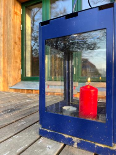 a red candle in a window on a wooden deck at Broockhof Ferienwohnung unterm Sternenhimmel in Mecklenburg in Reimershagen