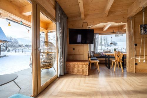 a living room with a television and a dining room at Stylowa Chata in Zakopane