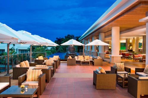 a hotel patio with chairs and tables and umbrellas at Sheraton Hua Hin Resort & Spa in Cha Am