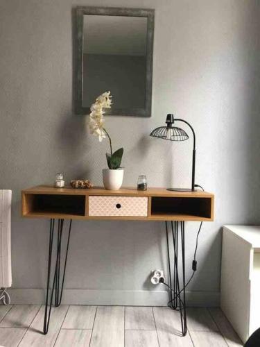 - un bureau avec un miroir et une lampe murale dans l'établissement Charmant appartement 2 pieces à 7 mn de paris, à Aubervilliers