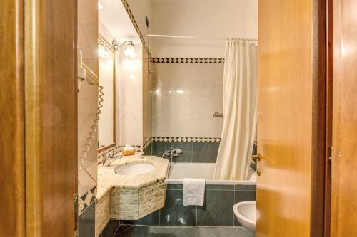 a bathroom with a sink and a toilet and a tub at Hotel Contilia in Rome