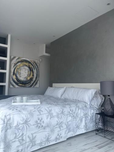 sypialnia z białym łóżkiem i obrazem na ścianie w obiekcie The7penthouse w mieście Santa Cruz de Tenerife