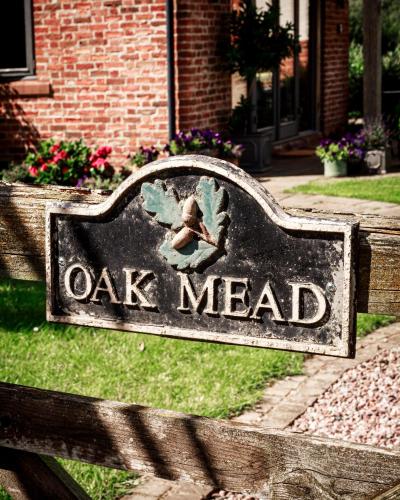 ein Zeichen, das Eiche liest und auf einer Bank sitzt in der Unterkunft Oak Mead in Wrexham