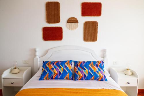 una camera da letto con un letto con cuscini colorati sul muro di Apartamento Maye a Bajamar