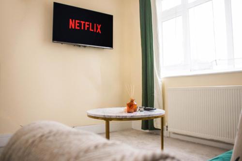 uma mesa num quarto com uma televisão na parede em 3 beds - Spacious garden em Streatham Vale