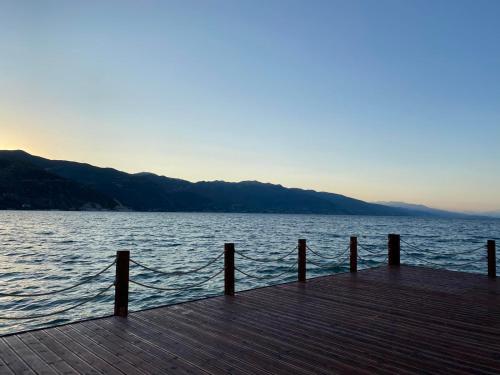 a dock with a fence on a body of water at Lilly Apartament in Pogradec