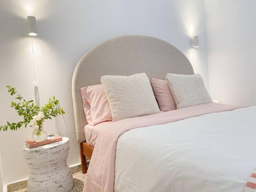 a bedroom with a large bed with pink and gray pillows at Casa Eve near Gozalandia Waterfalls in San Sebastian