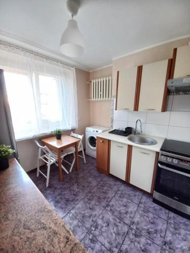 a small kitchen with a sink and a table at Tanie spanie na Grunwaldzkiej - ZAMELDOWANIE BEZOBSŁUGOWE- in Bydgoszcz