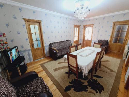 ein Wohnzimmer mit einem Esstisch und Stühlen in der Unterkunft Green garden Zargan villa in Qəbələ