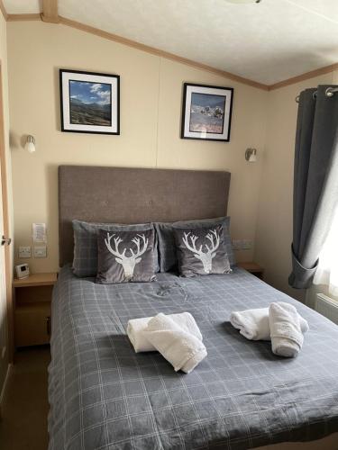 a bedroom with a bed with two towels on it at Freedom Lodge-Aviemore with FREE Starlink Superfast broadband 150mbps - All bedding and towels included - Pet Free in Aviemore