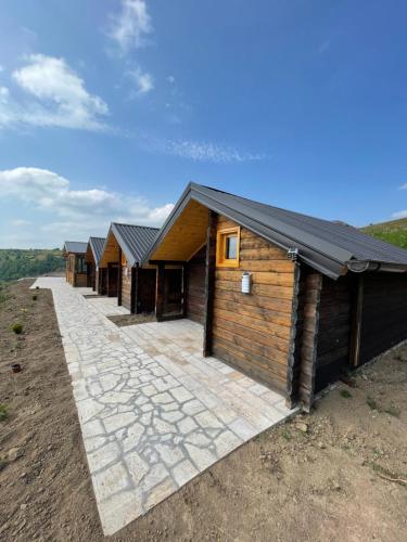 une rangée de cabanes en rondins sur une colline dans l'établissement Vikendice Moskva Uvac, à Sjenica