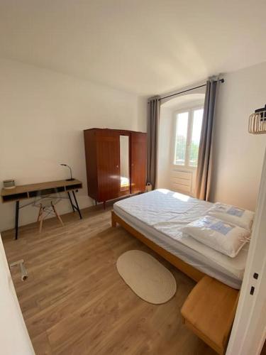 une chambre avec un lit et un bureau dans l'établissement Corte magnifique T2 45m2 neuf 5 personnes place st marcel hyper centre wifi lave linge tv, à Corte