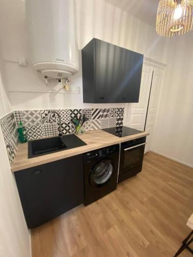 une cuisine avec un évier et une machine à laver dans l'établissement Corte magnifique T2 45m2 neuf 5 personnes place st marcel hyper centre wifi lave linge tv, à Corte